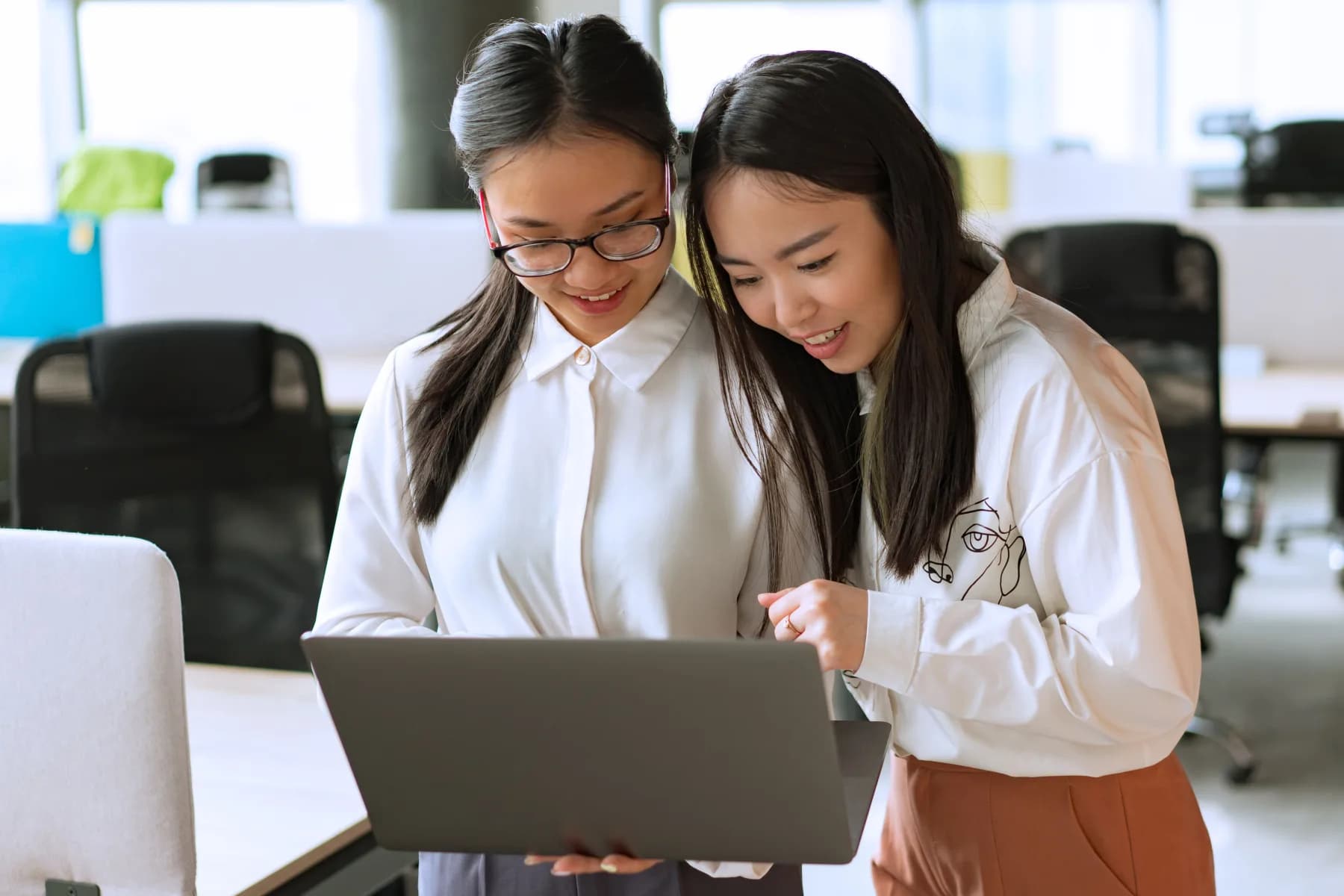 Two colleagues collaborating over a laptop