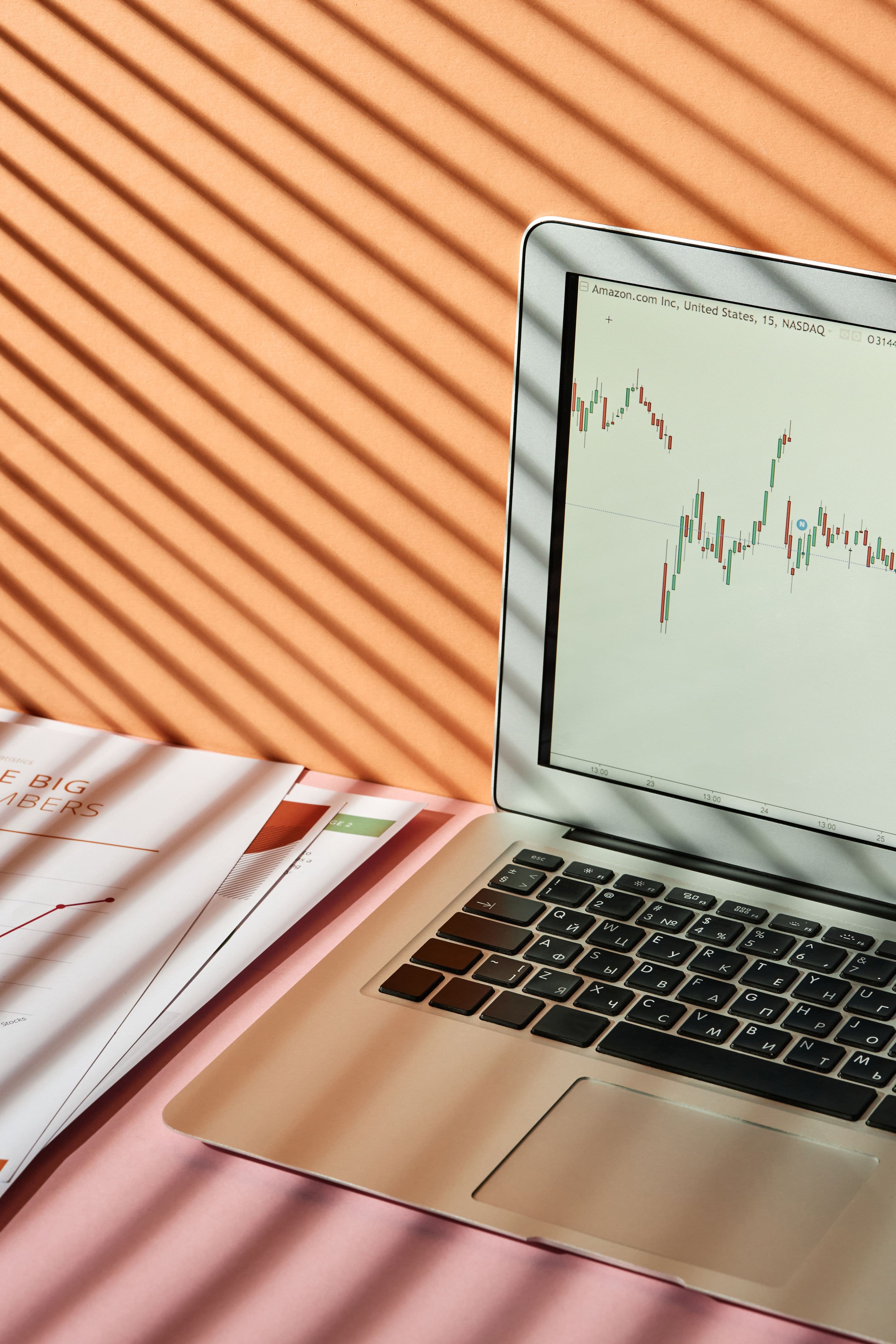 A laptop displaying a stock market graph on a desk